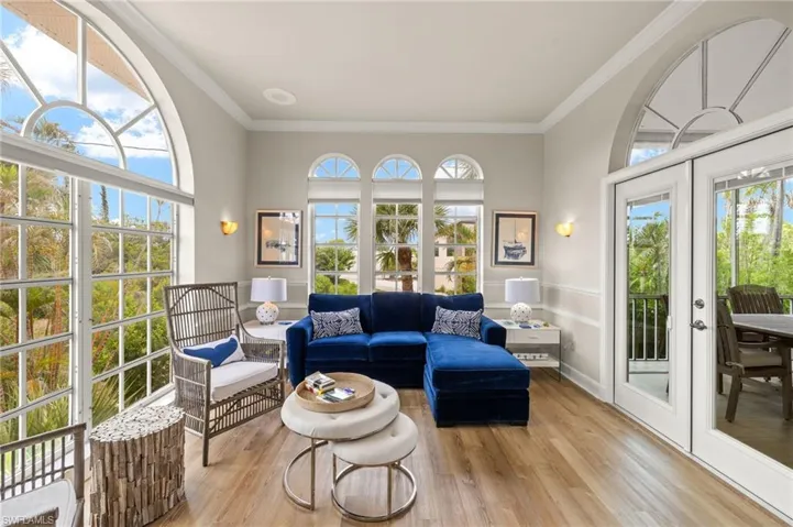 Inviting Den with French doors leading to lanai and screen enclosed pool.