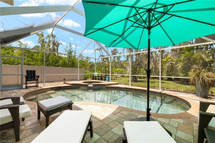 View of pool with a lanai, a patio, and a pool with connected hot tub