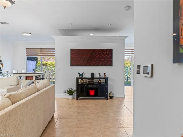 Living room with light tile patterned floors and ornamental molding