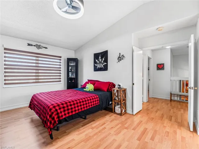Bedroom featuring lofted ceiling and light wood-style flooring