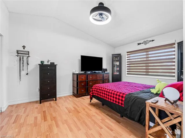 Bedroom featuring lofted ceiling and light wood-style flooring