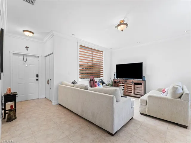 Living room featuring ornamental molding and light tile patterned floors