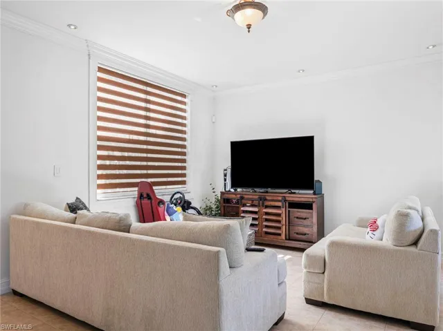 Living room with ornamental molding and light tile patterned floors