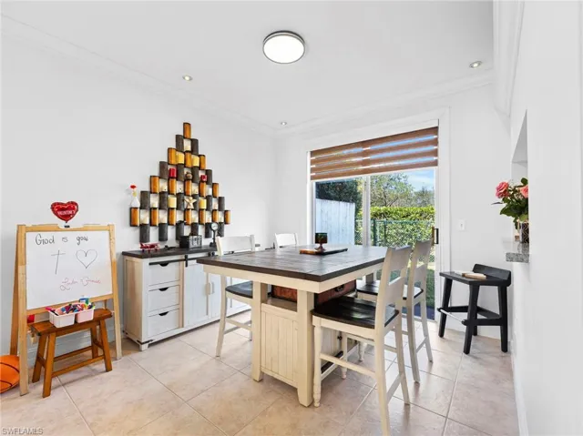Dining room with ornamental molding and light tile patterned floors