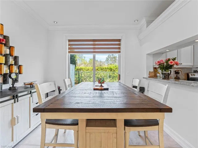 Dining space featuring light tile patterned floors, crown molding, and recessed lighting