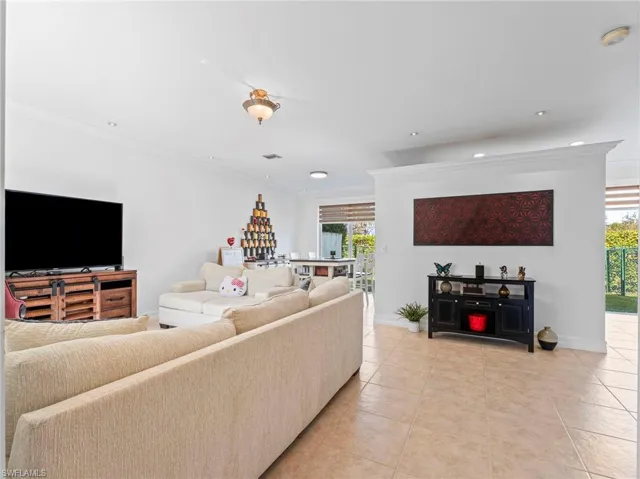 Living area featuring ornamental molding and light tile patterned flooring
