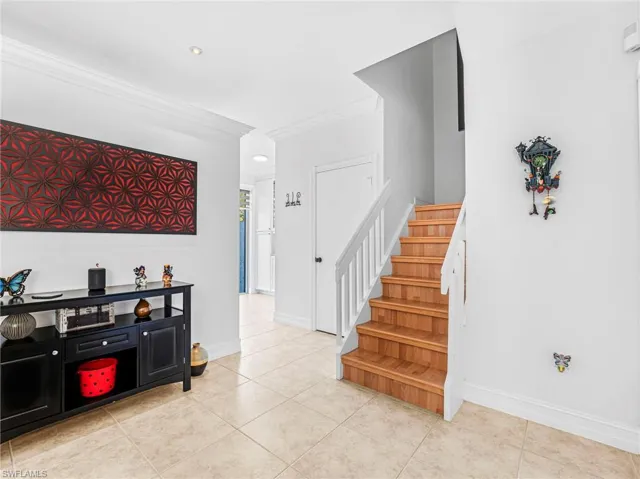 Stairs with crown molding, tile patterned flooring, and recessed lighting