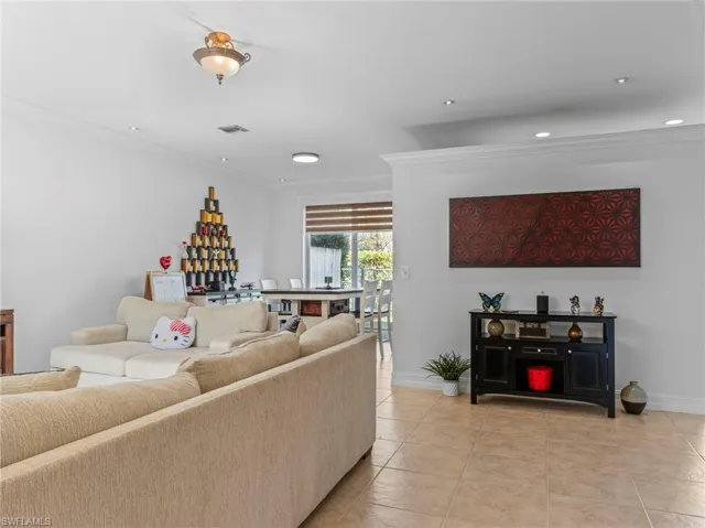 Living room featuring crown molding and light tile patterned floors