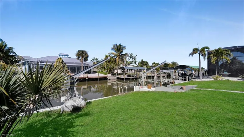 Dock featuring a yard, boat lift, and a water view