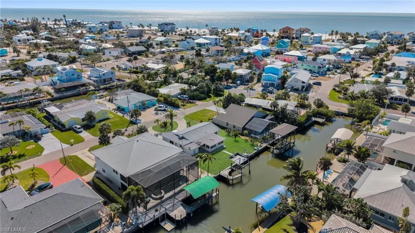 Aerial view of property and surrounding area with a large body of water and nearby suburban area