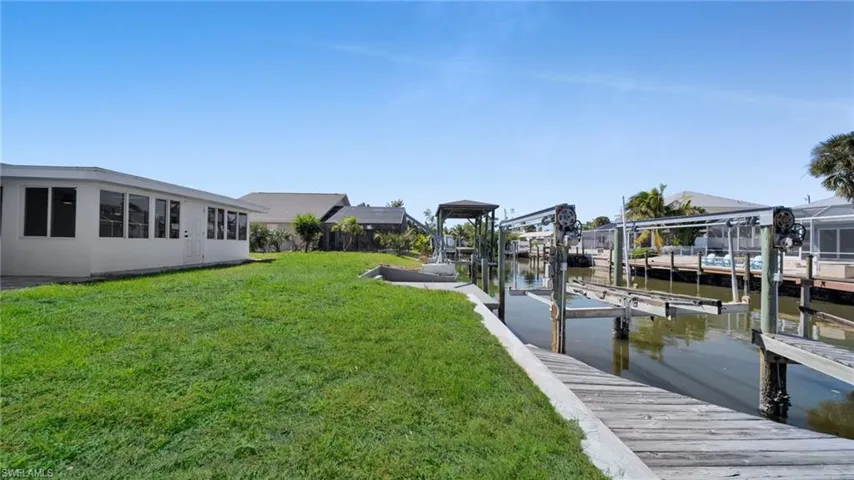 Dock with a lawn, a water view, and boat lift