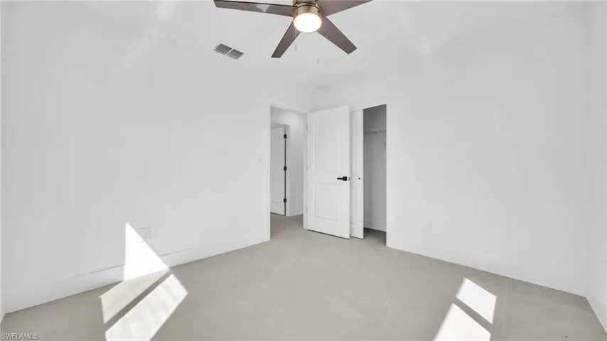 Unfurnished bedroom with a ceiling fan and a closet