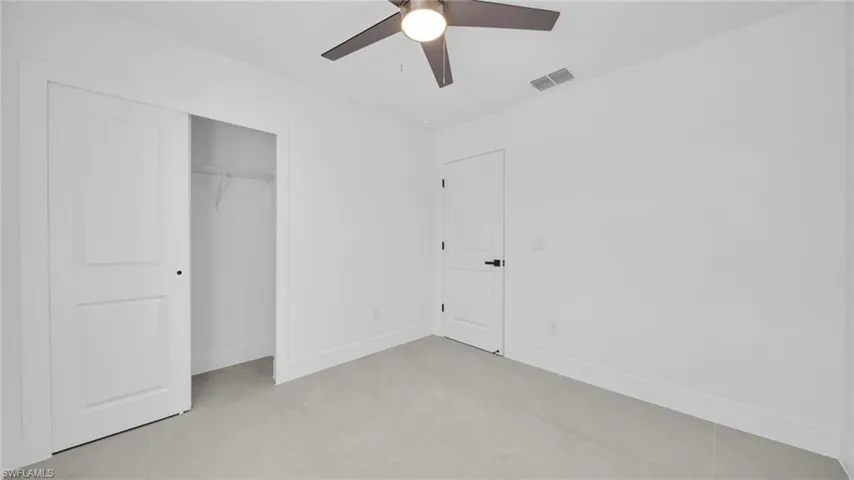Unfurnished bedroom with ceiling fan and a closet