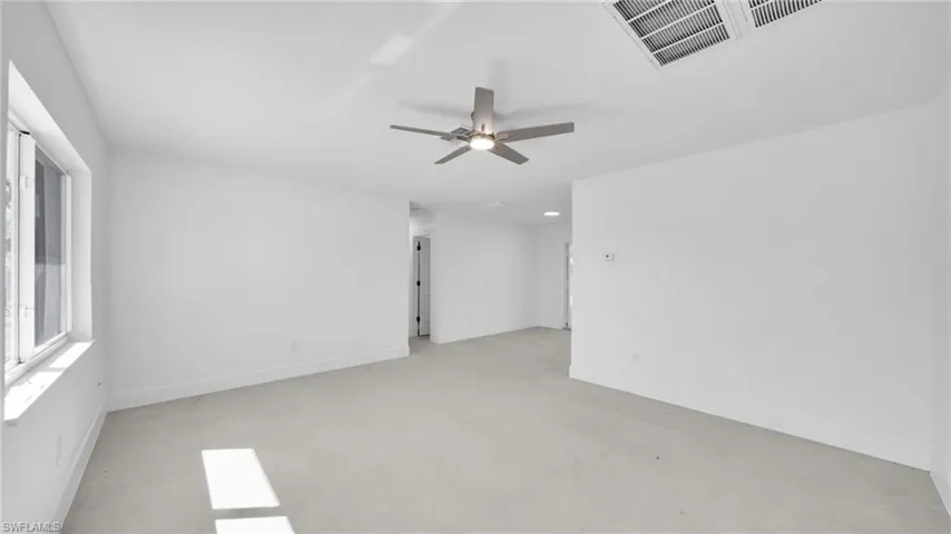 Unfurnished room with a ceiling fan and baseboards