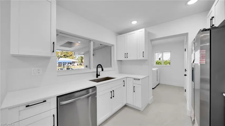 Kitchen with stainless steel appliances, white cabinetry, independent washer and dryer, plenty of natural light, and recessed lighting
