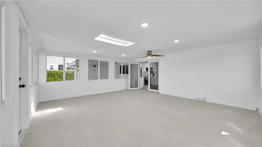 Unfurnished room with a skylight, concrete flooring, recessed lighting, and a ceiling fan