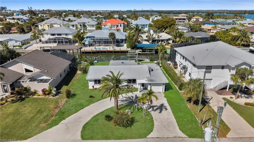 Aerial perspective of suburban area featuring a nearby body of water