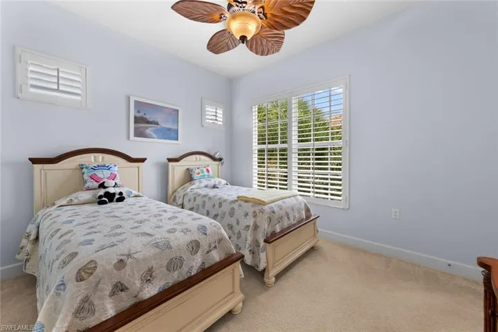 Carpeted bedroom featuring ceiling fan