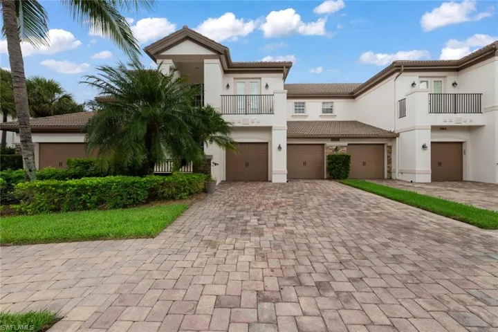 View of front of home with a garage and a balcony