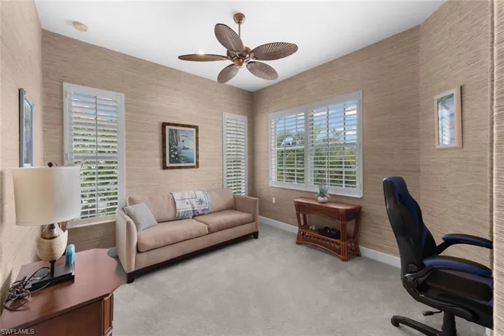 Office with carpet floors and ceiling fan