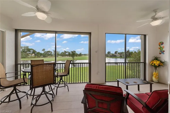 Sunroom with a healthy amount of sunlight, a water view, and ceiling fan