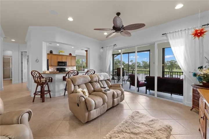 Living room featuring crown molding, light tile patterned floors, and ceiling fan