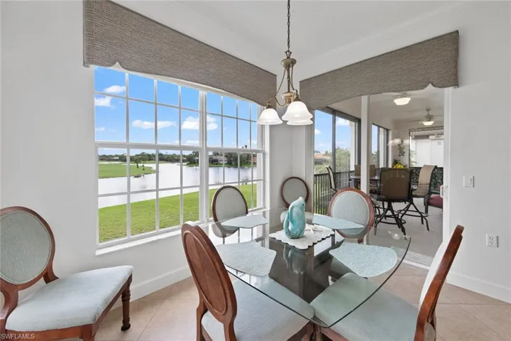Dining area with a water view, light tile patterned floors, and ceiling fan