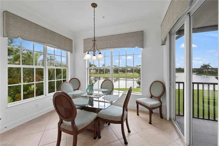 Sunroom / solarium with a water view, a notable chandelier, and plenty of natural light