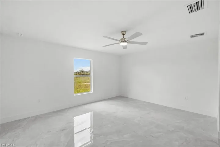 Empty room with ceiling fan and baseboards