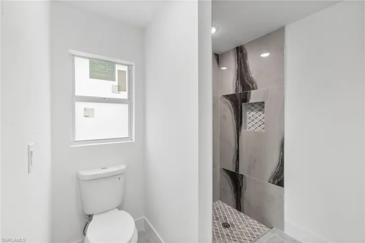 Bathroom featuring baseboards and a tile shower