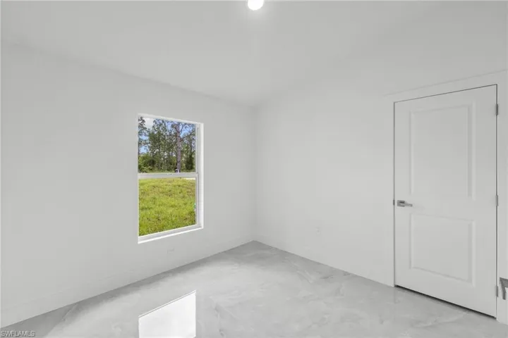Empty room featuring light marble finish floors and baseboards