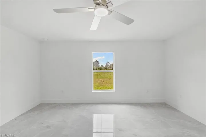 Empty room with ceiling fan and baseboards