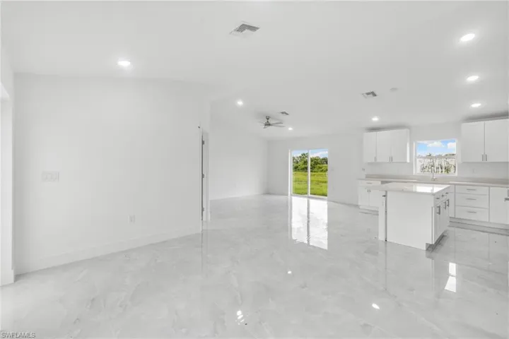 Unfurnished living room featuring recessed lighting, light marble finish floors, and ceiling fan