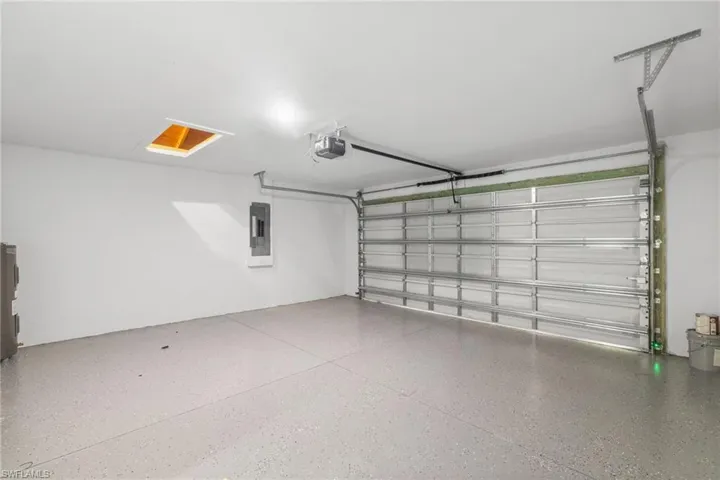Garage featuring a garage door opener and electric panel