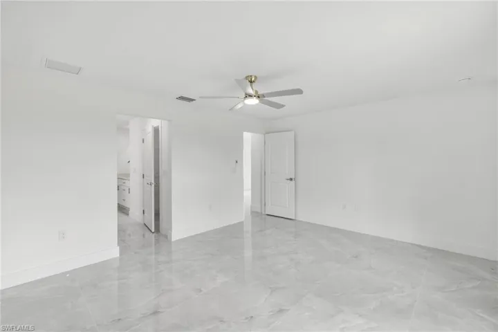 Spare room with a ceiling fan and light marble finish floors