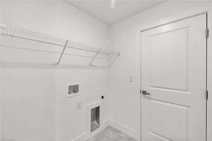 Laundry room with electric dryer hookup, light marble finish floors, and washer hookup