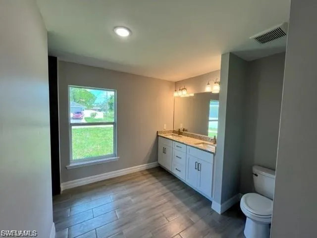 Bathroom with double vanity and light wood finished floors