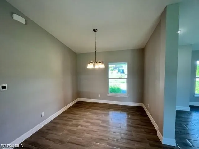 Unfurnished dining area featuring wood finish floors and suspended lighting