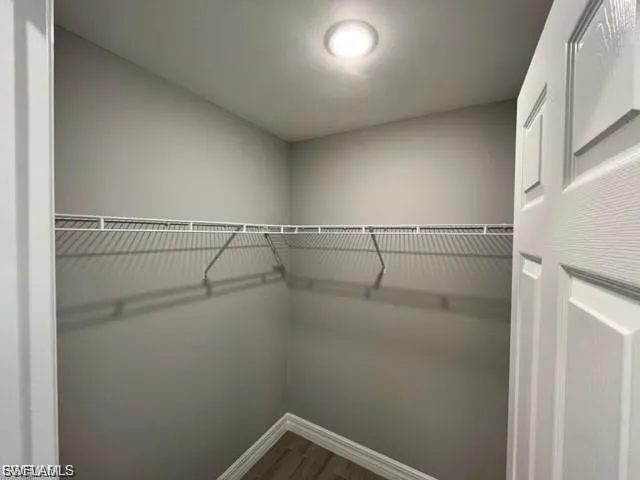 Walk in closet featuring dark wood-type flooring