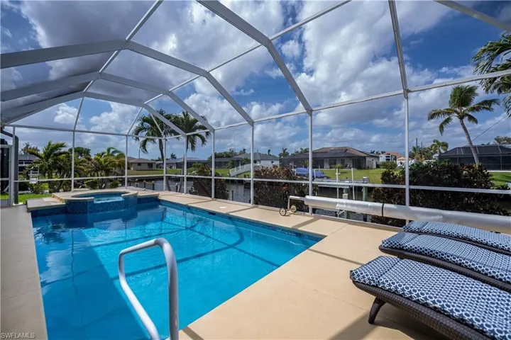 View of pool with a patio, a residential view, a lanai, and a pool with connected hot tub