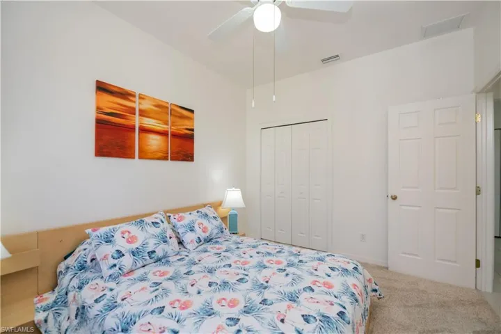 Carpeted bedroom featuring ceiling fan, a closet