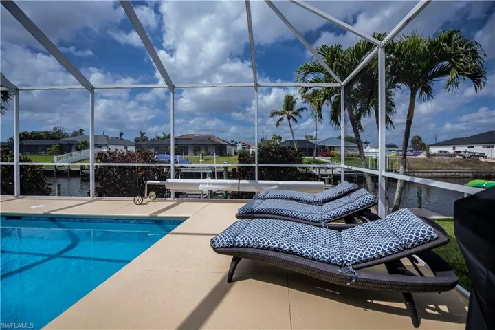 Outdoor pool featuring a patio area, a lanai, and a water view