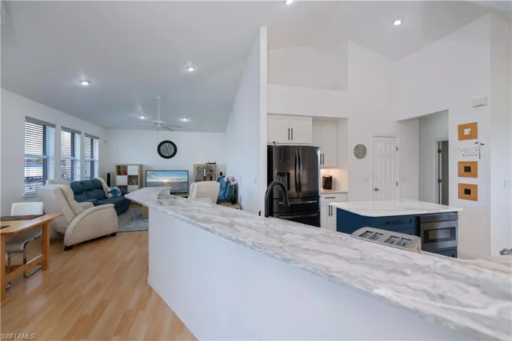 Kitchen with white cabinets, breakfast bar, quartz counter tops