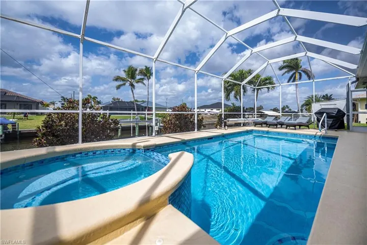 Outdoor pool featuring a lanai, a grill, and a patio