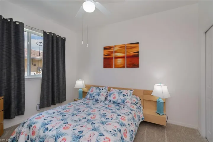 Carpeted bedroom featuring a ceiling fan