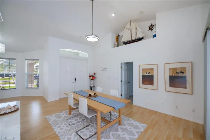 Dining space or living room, high vaulted ceiling, and light wood-style floors