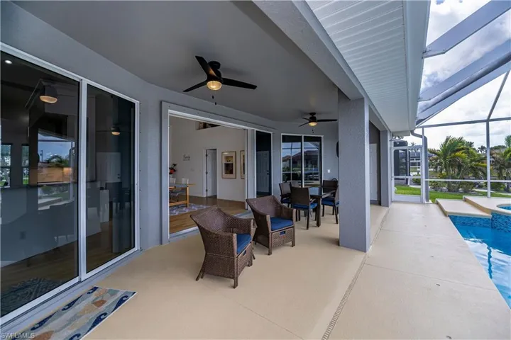 View of patio / terrace featuring outdoor dining area, a lanai, a ceiling fan, and an outdoor pool