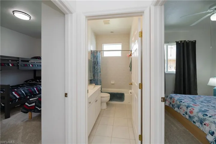 Full bath featuring shower / tub combo vanity, and tile patterned floors