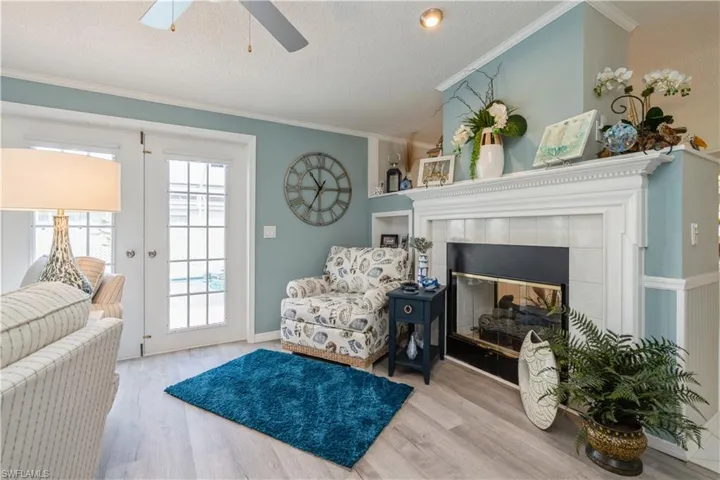 Living area featuring light hardwood / wood-style floors, a tile fireplace, crown molding, and a textured ceiling
