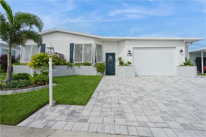 View of front of property featuring a front yard and a garage